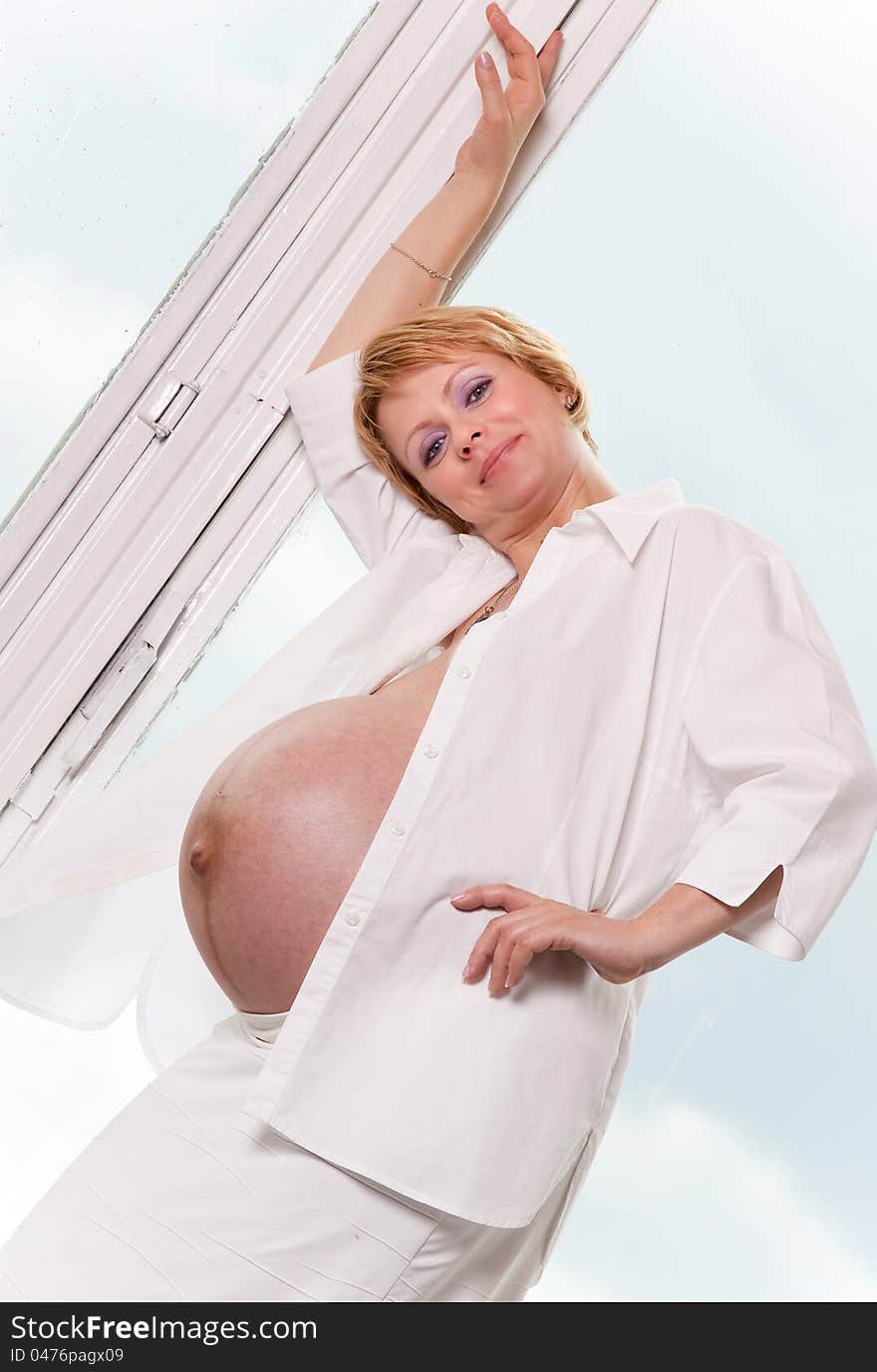 Pregnant woman standing by the window