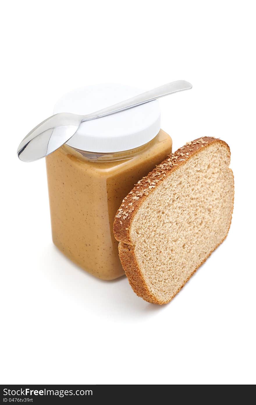 Jar of Peanut Butter with spoon and bread, isolated on white, copy space