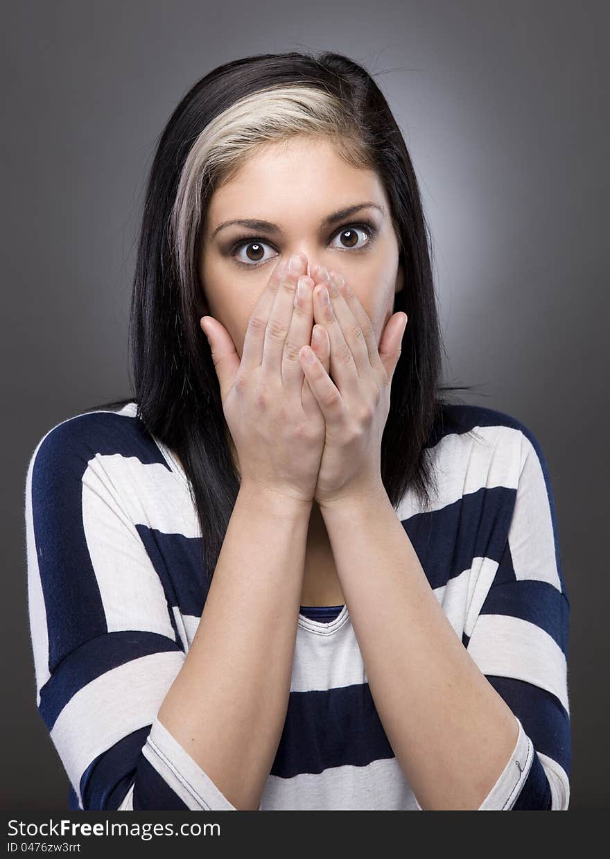 A caucasian woman puts her hand over her face in shock. A caucasian woman puts her hand over her face in shock