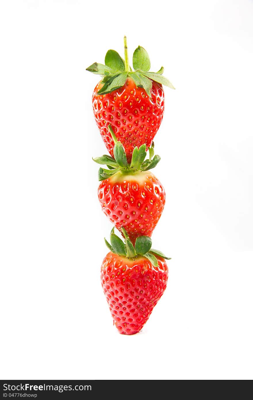 A picture of three strawberries stacked on top of eachother. A picture of three strawberries stacked on top of eachother