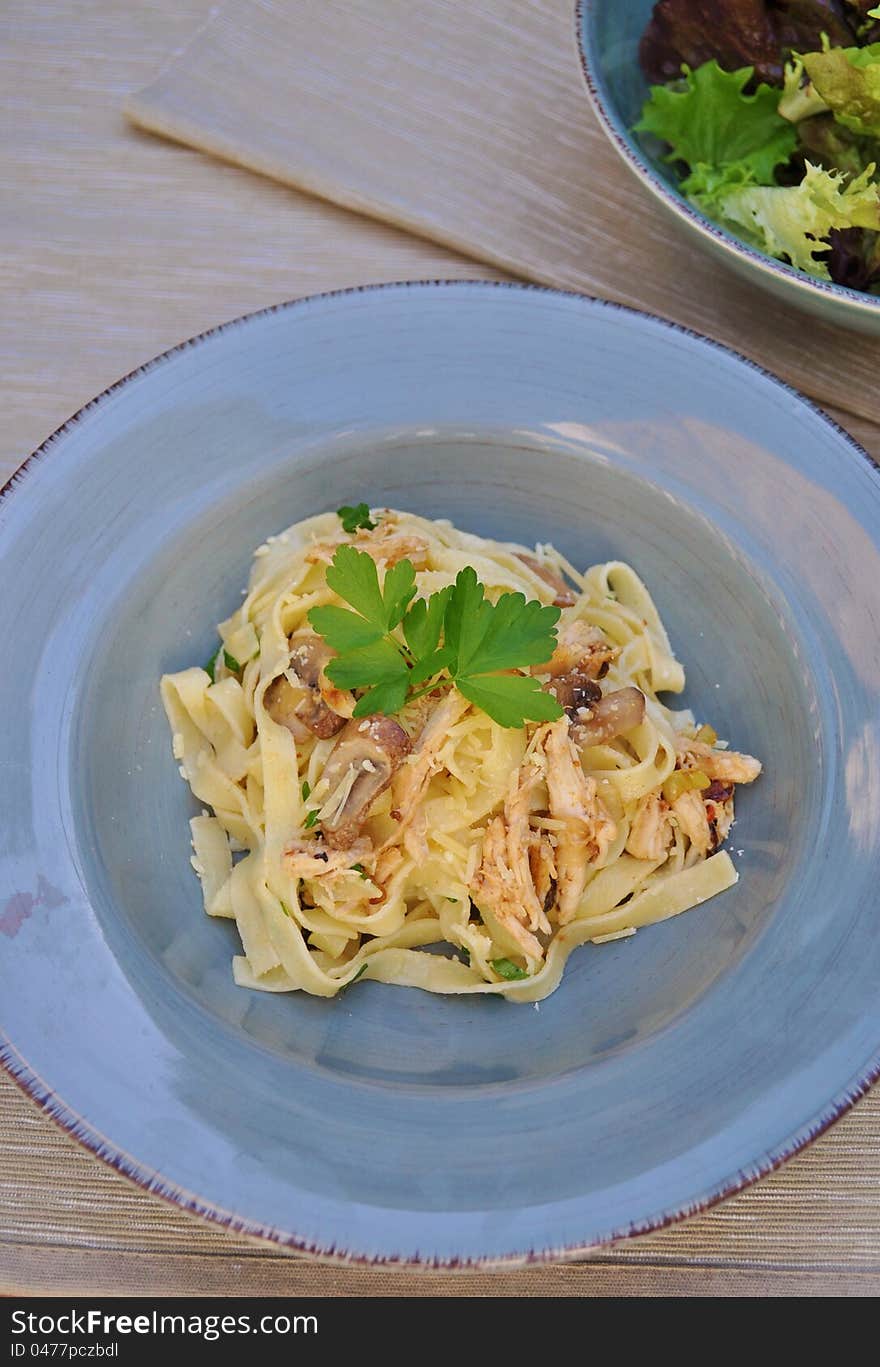 Bowl of fettucine pasta with salad