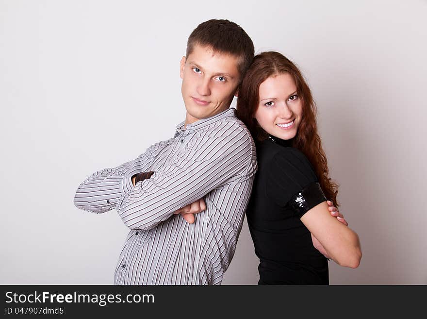 Young couple with folded hands and look camera