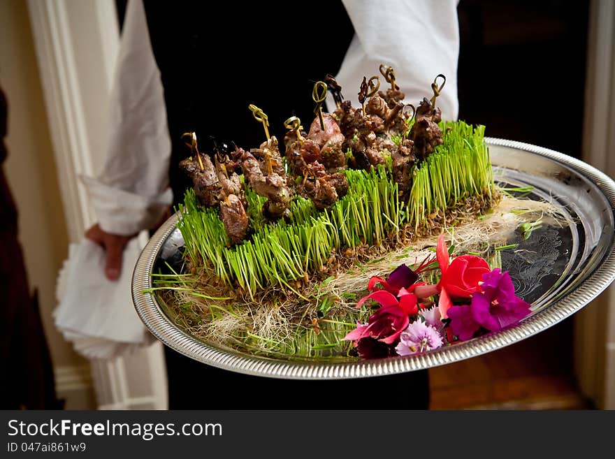 Waiter serving a plate of food during a wedding. Waiter serving a plate of food during a wedding