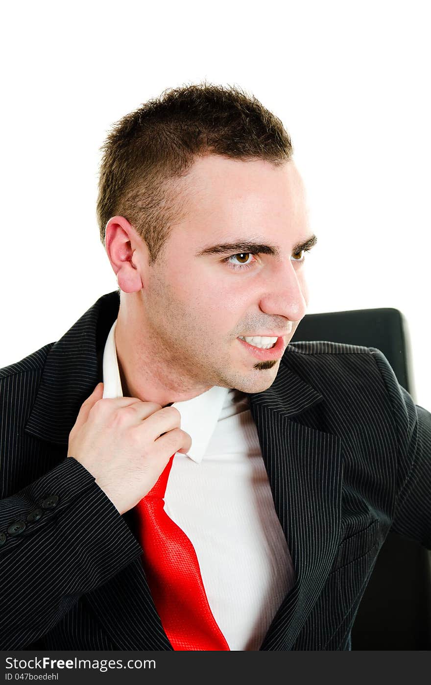 Stressed young businessman yanking necktie in frustration. Stressed young businessman yanking necktie in frustration