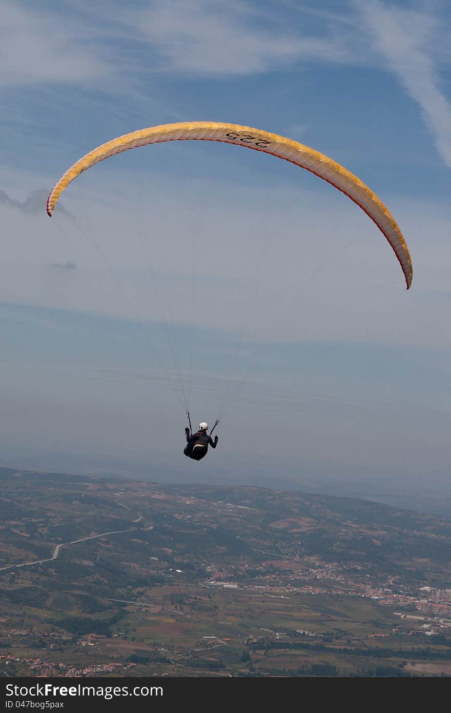 Paraglider in a yellow/orange paraglide over Bornes (north Portugal, Europe) landscape