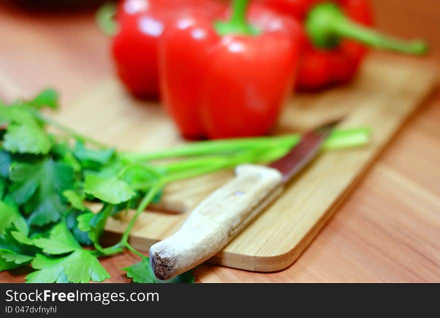 Healthy red peppers, green parsley and knife for cutting and preparing a dinner. Healthy red peppers, green parsley and knife for cutting and preparing a dinner.