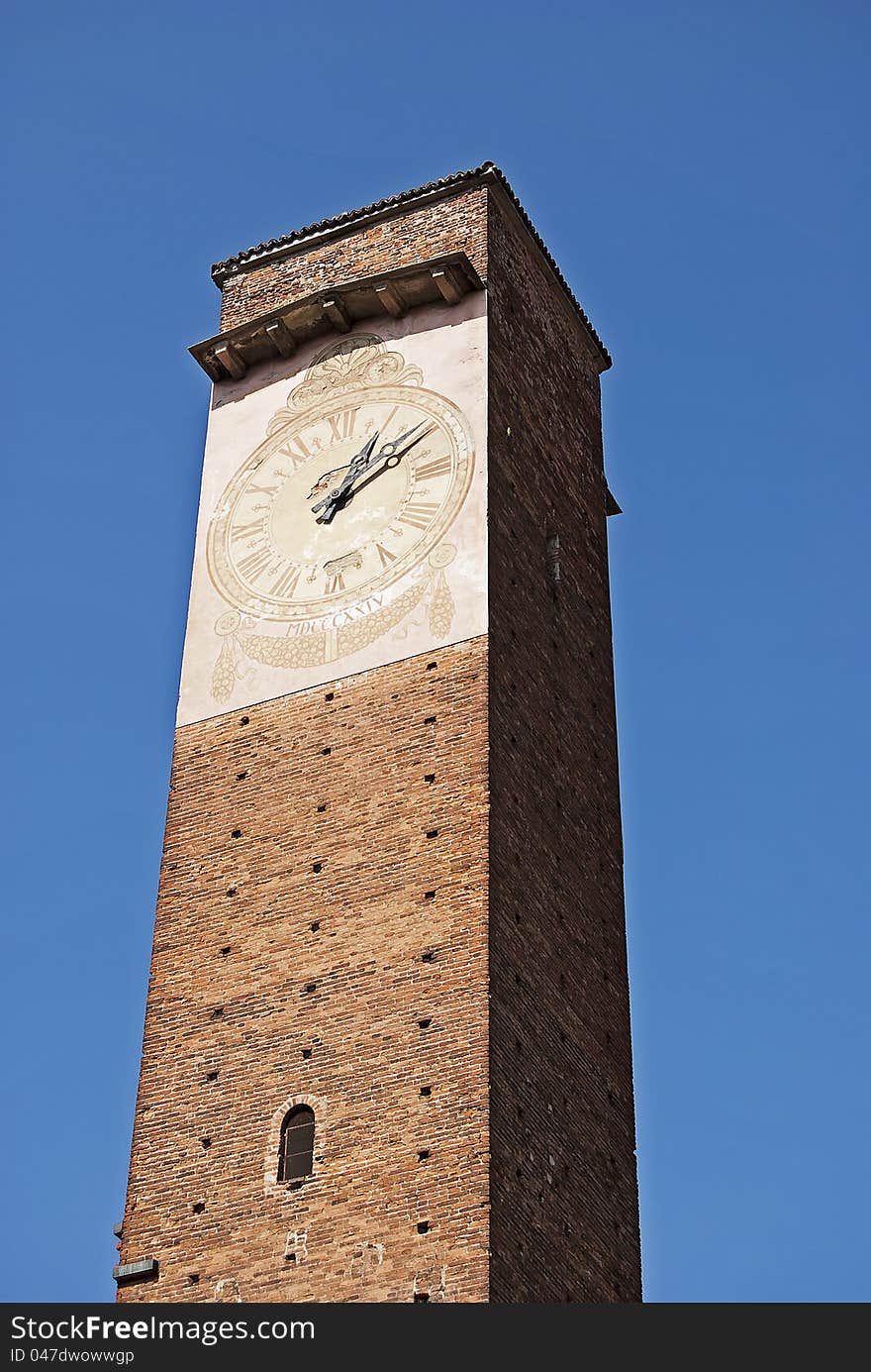 Ancient italian medieval civil tower with clock in the city of Pavia. Ancient italian medieval civil tower with clock in the city of Pavia