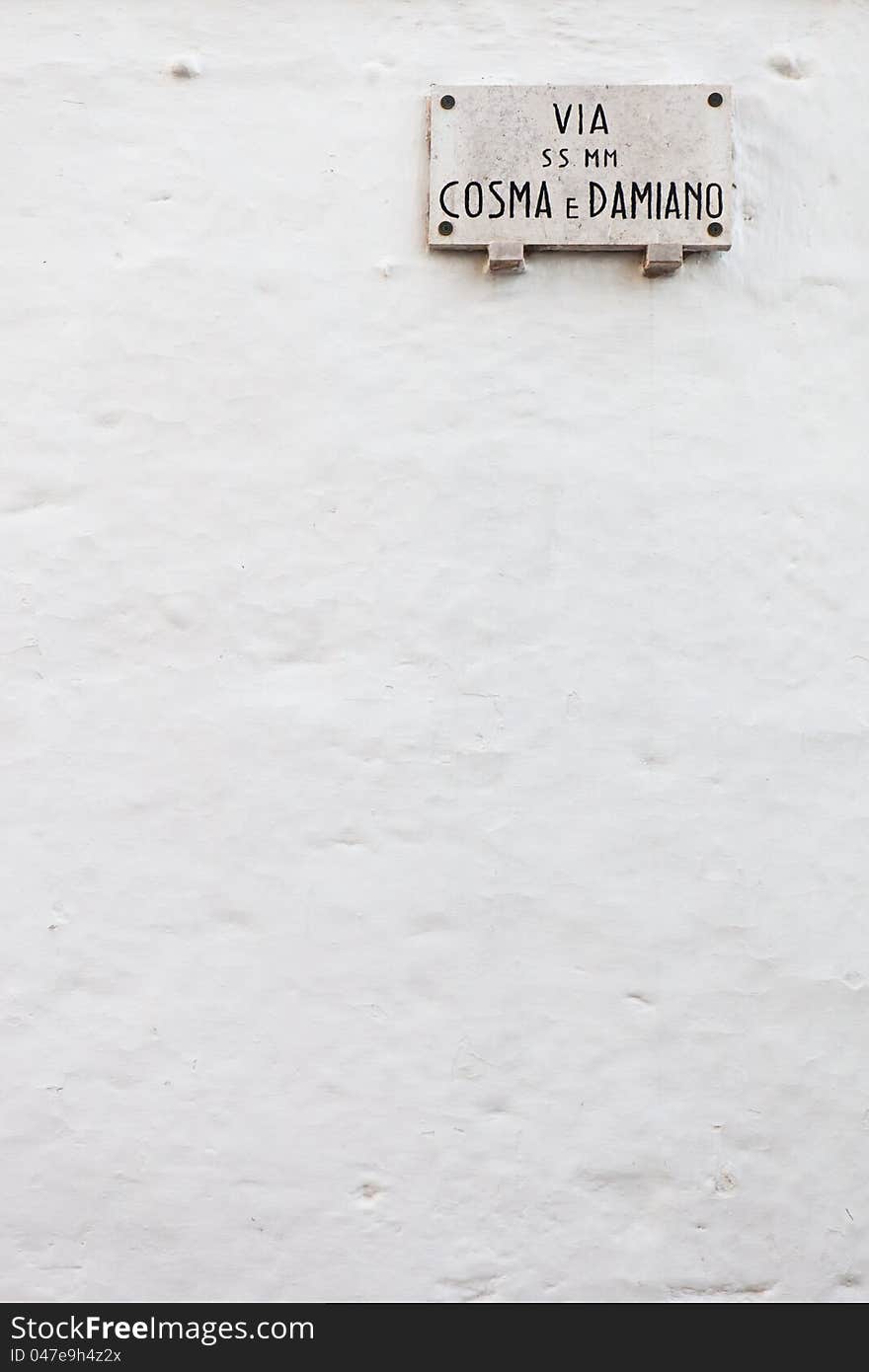 Italian street name plate on a white painted wall