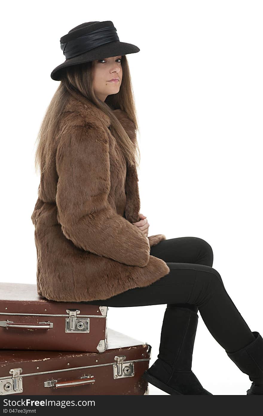 Woman is sitting on the luggage, studio shot. Woman is sitting on the luggage, studio shot