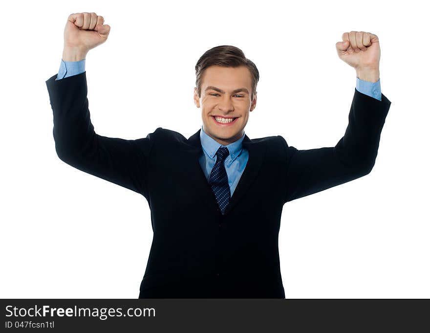 Portrait of confident young businessman celebrating success with arms up