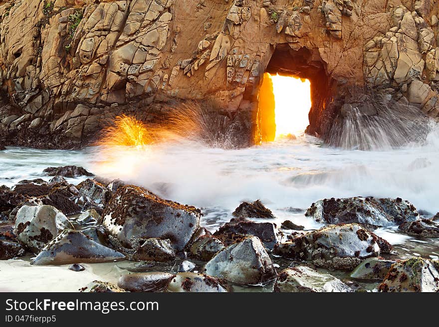 Sunsetting light coming through opening at famous Pfeiffer Beach, California. Sunsetting light coming through opening at famous Pfeiffer Beach, California.