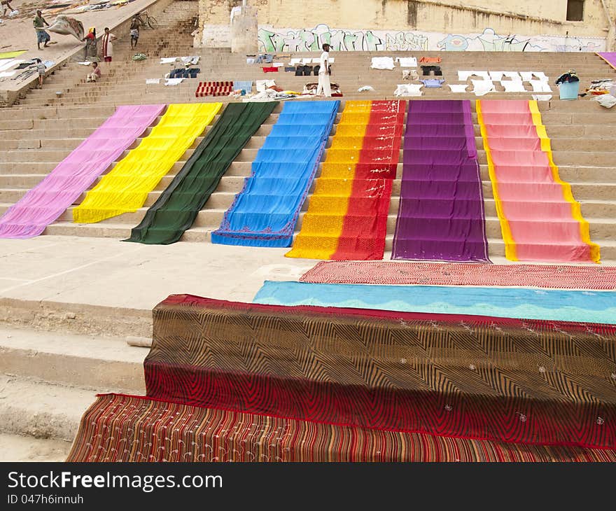 Long colorful cloth laying to dry on the ghats at the Ganges river in Varanasi, India. Long colorful cloth laying to dry on the ghats at the Ganges river in Varanasi, India