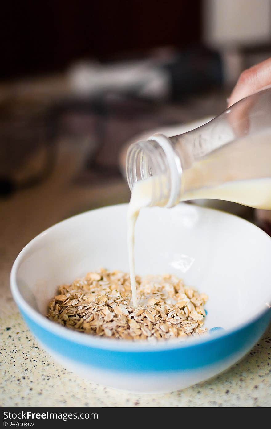 Milk flowing on a bowl of cornflakes