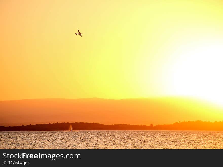 Sunset on the lake with airplane flight. Sunset on the lake with airplane flight