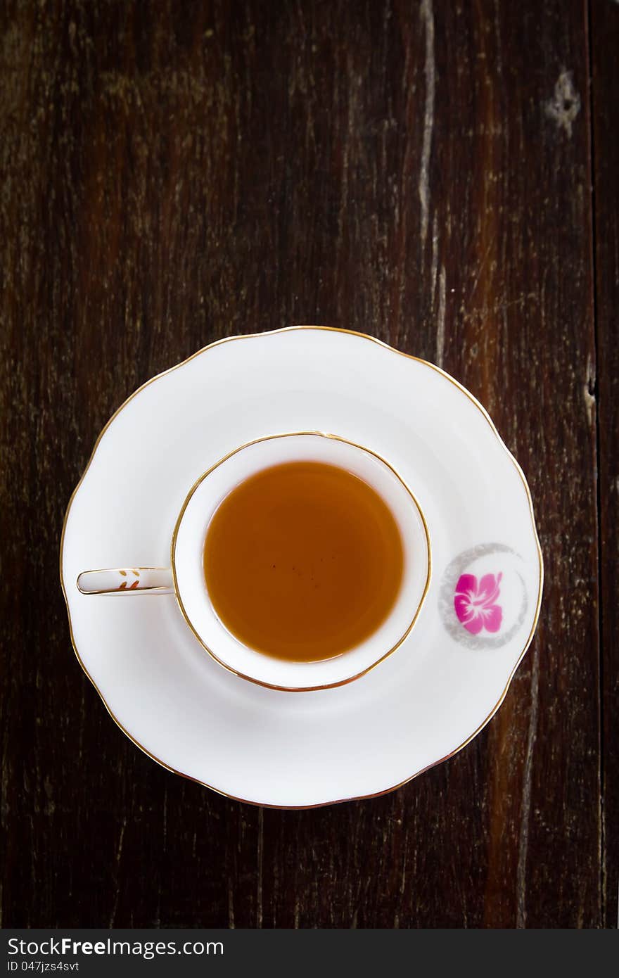 White cup of tea on wooden table