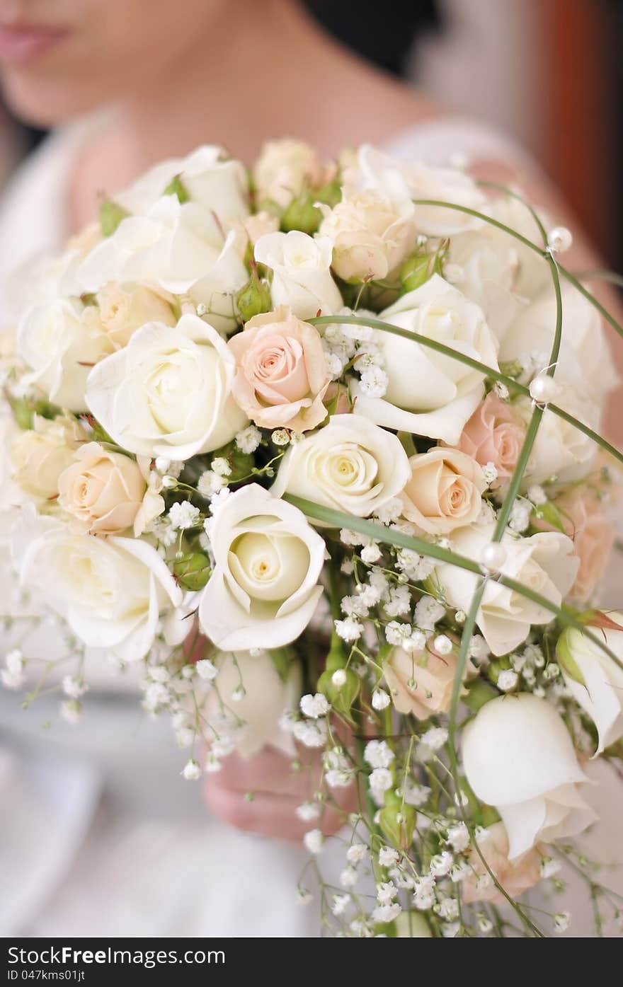 A bride holds her bouquet of  roses. A bride holds her bouquet of  roses.