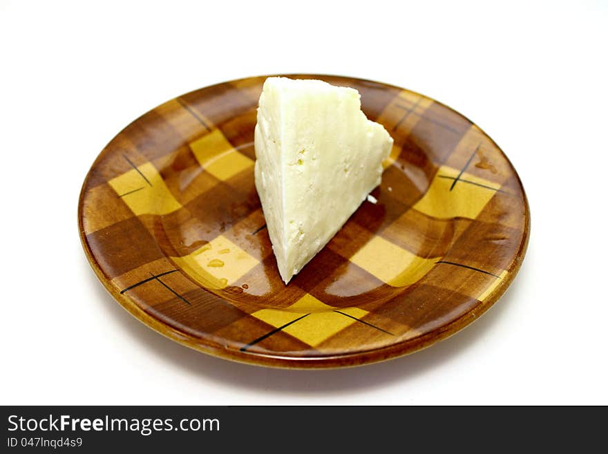 A delicious cheese on a plate closeup on white background. A delicious cheese on a plate closeup on white background