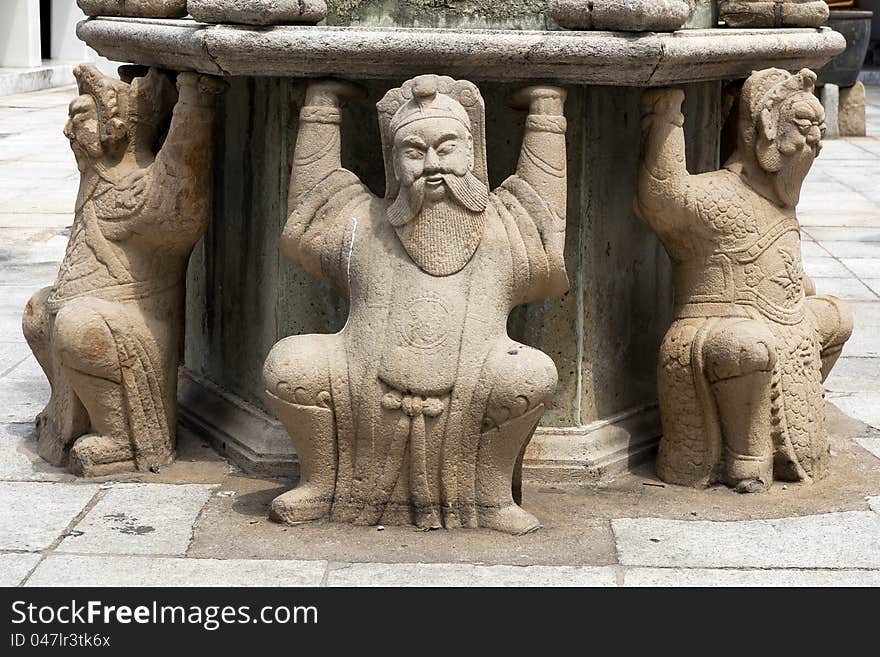 Three man chinese stone sitting on ground .