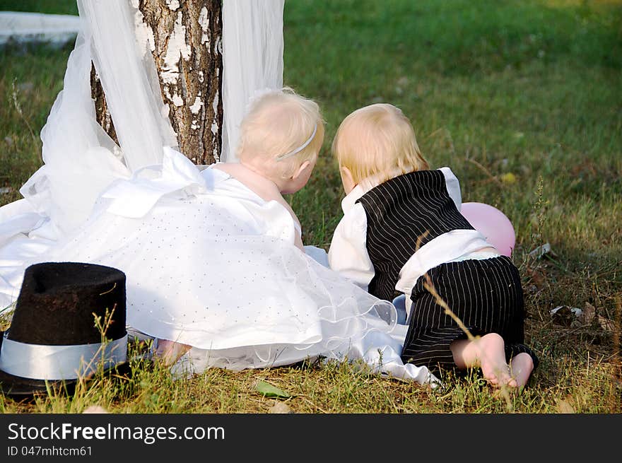 Children dressed as bride and groom play with each other