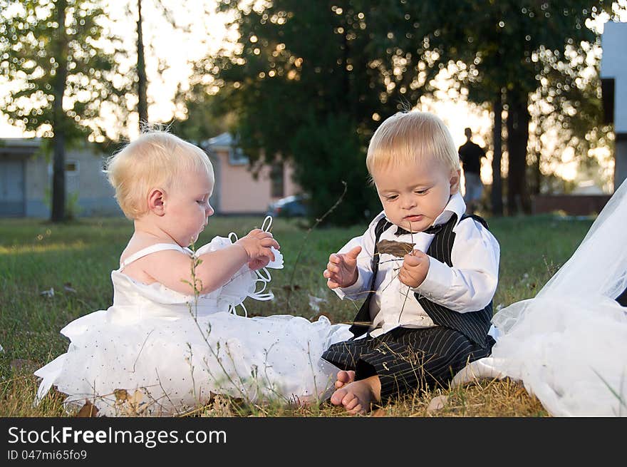 Children dressed as bride and groom play with each other