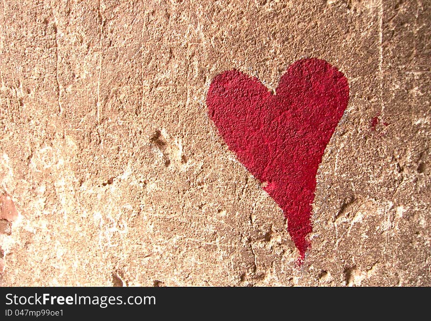 Red heart drawn over brown textured wall. Red heart drawn over brown textured wall