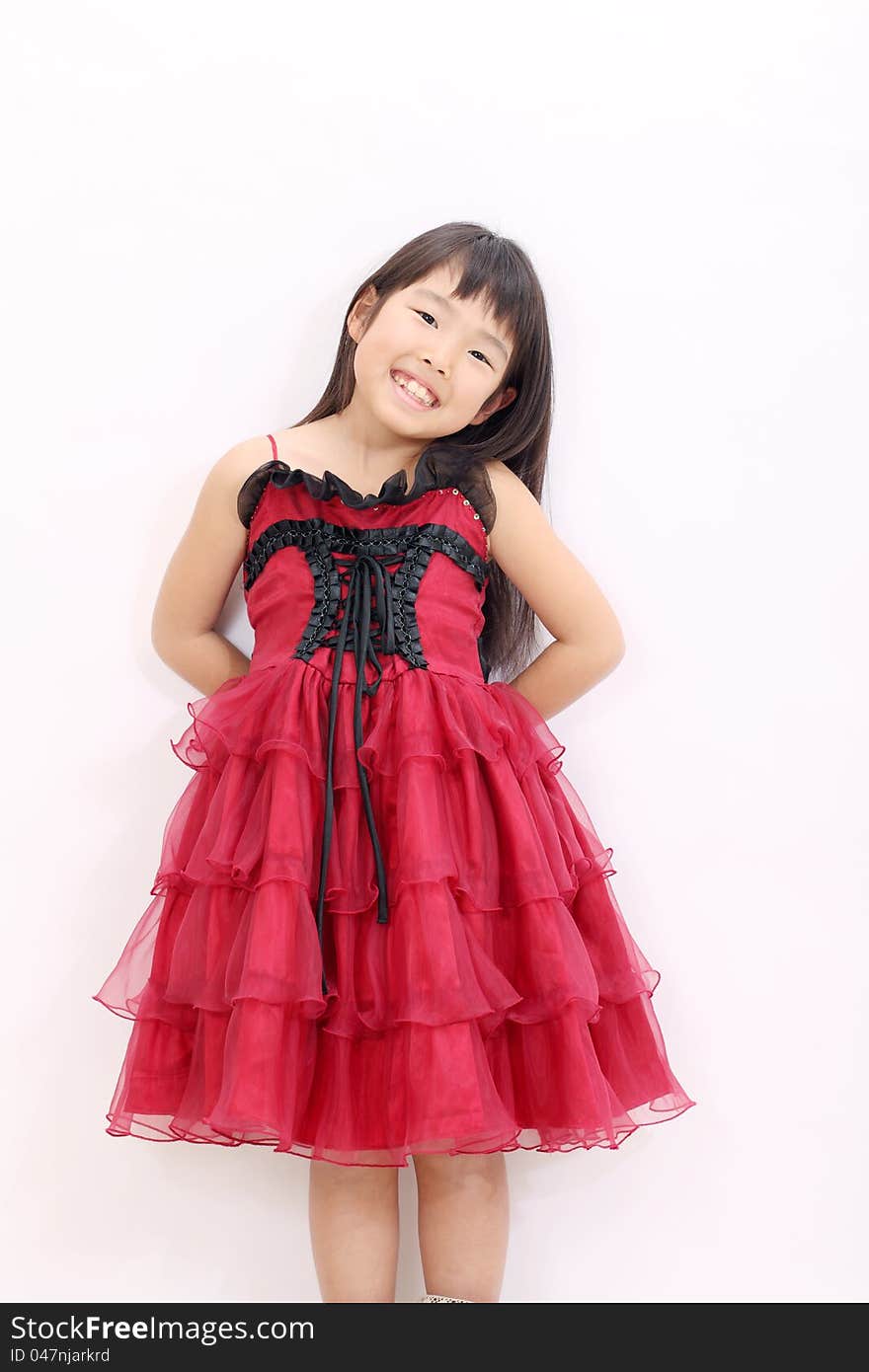 Little asian girl wearing dress, with hands at her back. Little asian girl wearing dress, with hands at her back