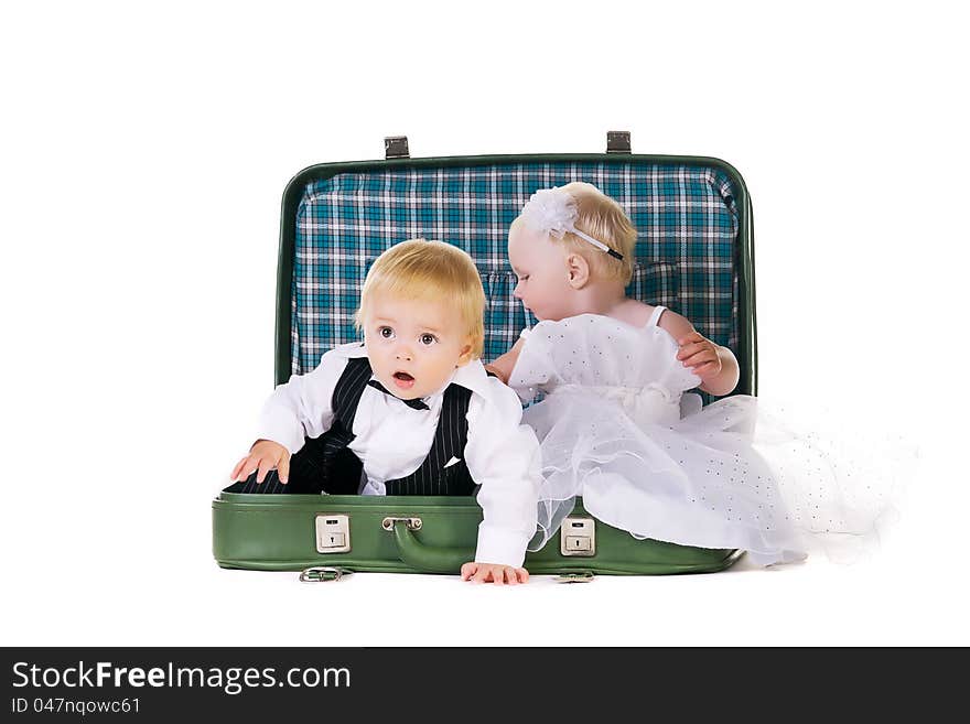 Boy and a girl dressed as newlyweds sitting in a suitcase, going to travel. Boy and a girl dressed as newlyweds sitting in a suitcase, going to travel