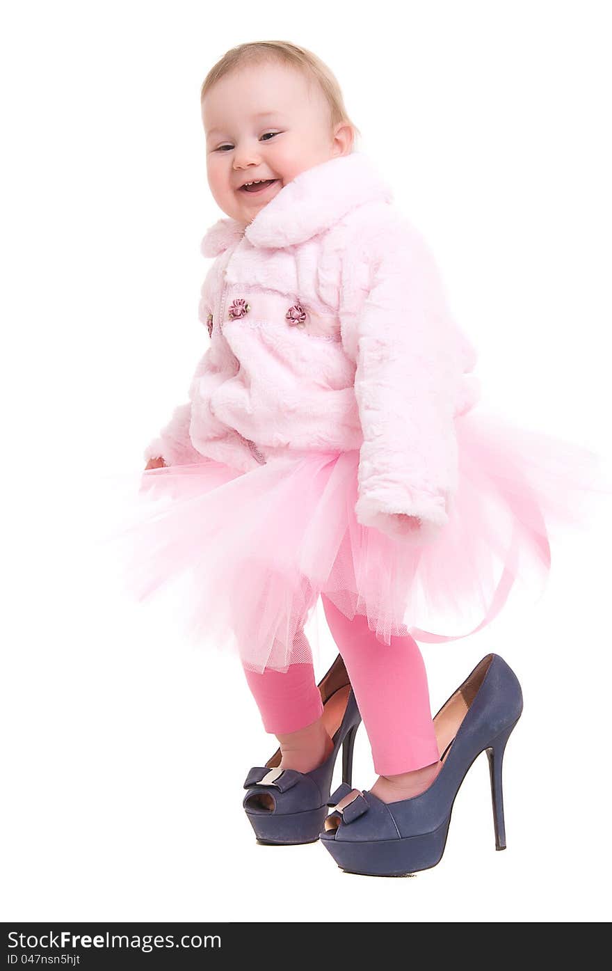 Happy baby in the shoes of adults, and a pink tutu on the white backgraund