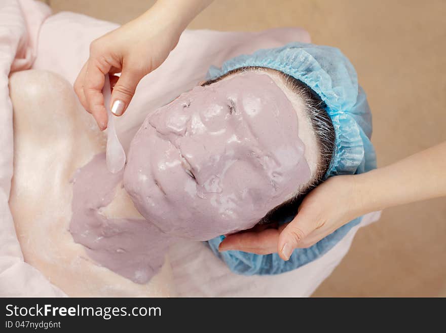 Facial seaweed mask applying in beauty salon