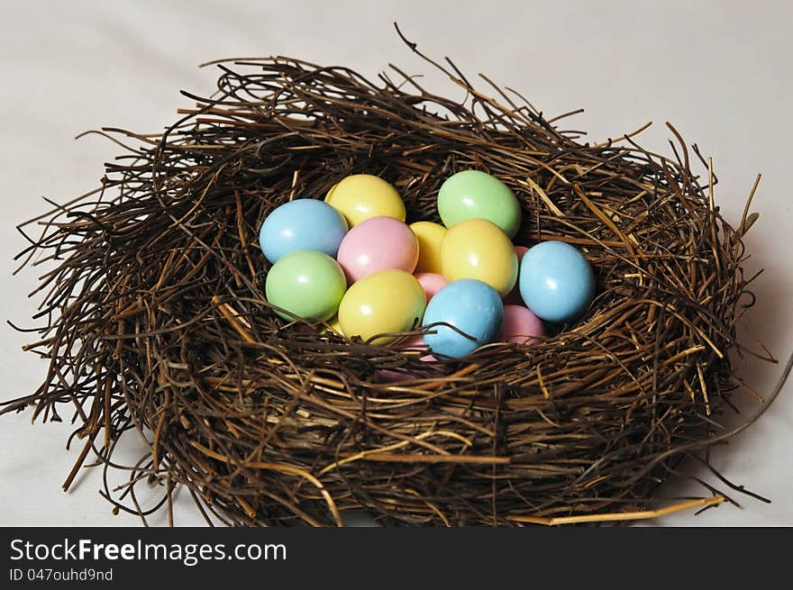 Birds nest full of colorful chocolate easter eggs. Birds nest full of colorful chocolate easter eggs