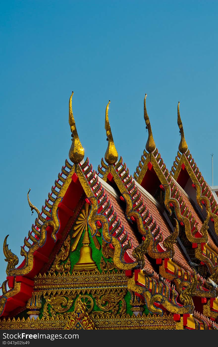 Golden temple gable with a clear blue sky