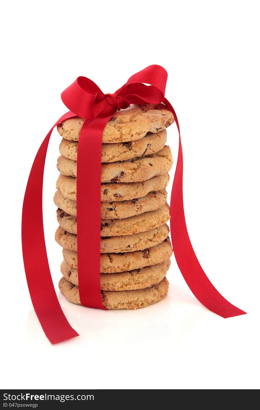 Chocolate chip cookie stack tied with a red satin ribbon over white background. Chocolate chip cookie stack tied with a red satin ribbon over white background.