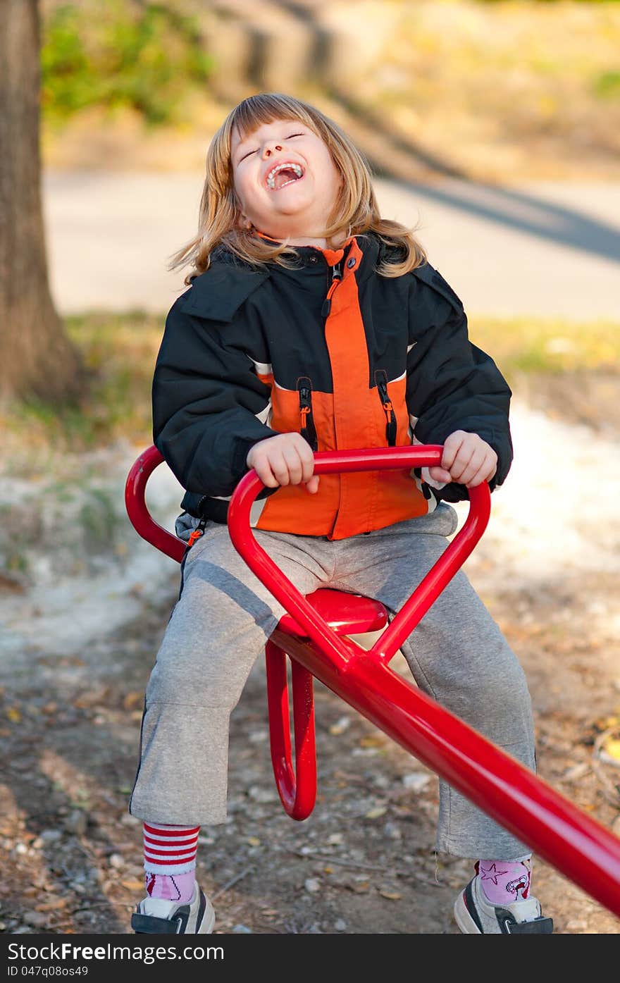 Cute little girl enjoying her ride on the teeter. Cute little girl enjoying her ride on the teeter.