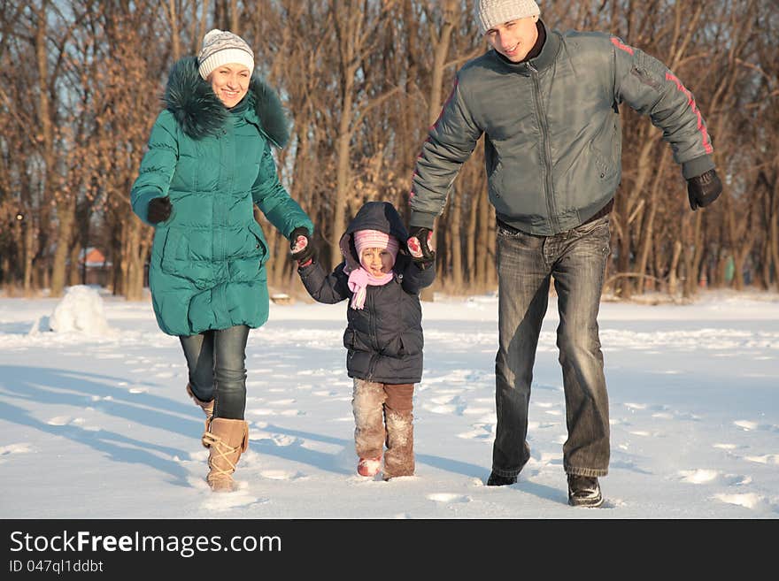 Happy family lying on the snow in the winter