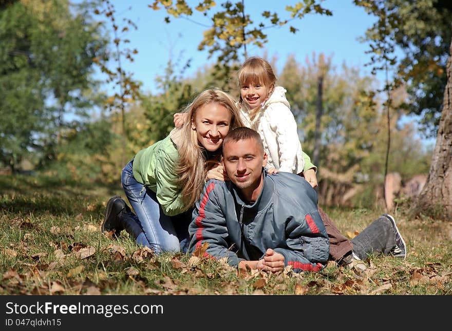 Young happy family in autumn park. Young happy family in autumn park.