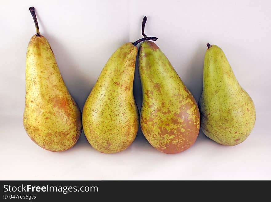 Four juicy ripe golden pears on a gray background. Healthy food. Four juicy ripe golden pears on a gray background. Healthy food.