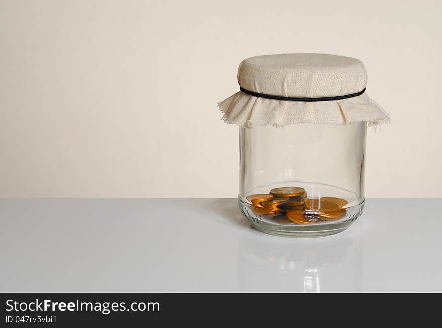 Savings - coins in a jar with copy space