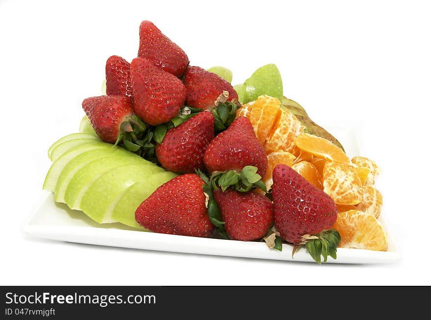 A large plate of sliced fruit on white background. A large plate of sliced fruit on white background