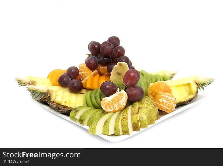 A large plate of sliced fruit on white background. A large plate of sliced fruit on white background