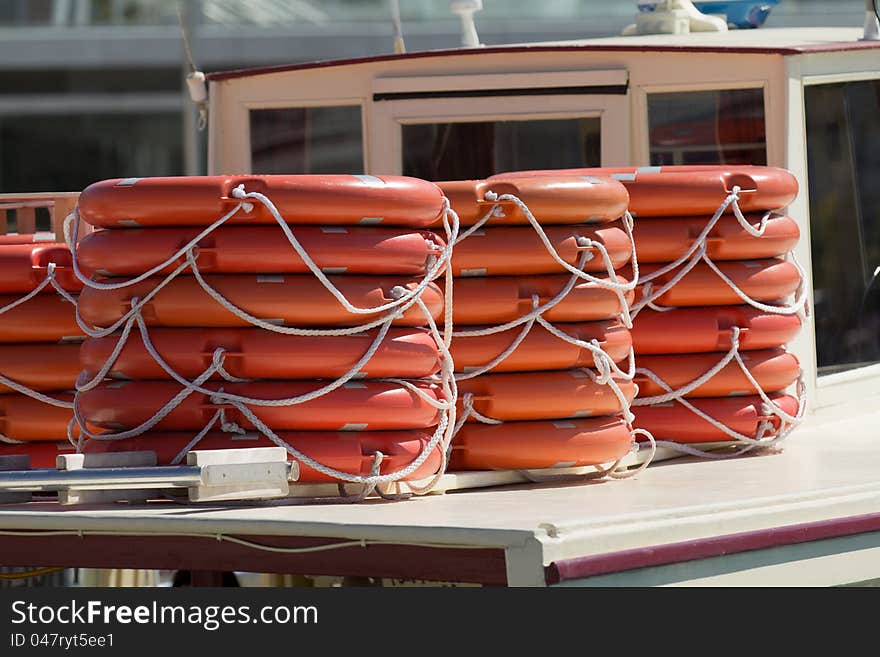 Stacked lifebelts over a ship deck on a sunny day