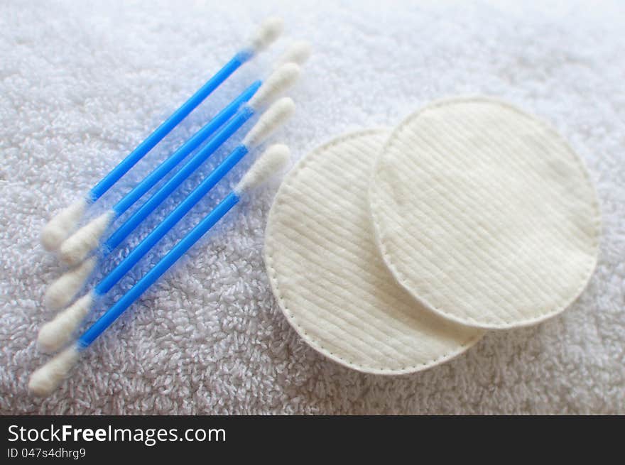 Objects for body-care and personal hygiene: cotton swabs and pads on white towel