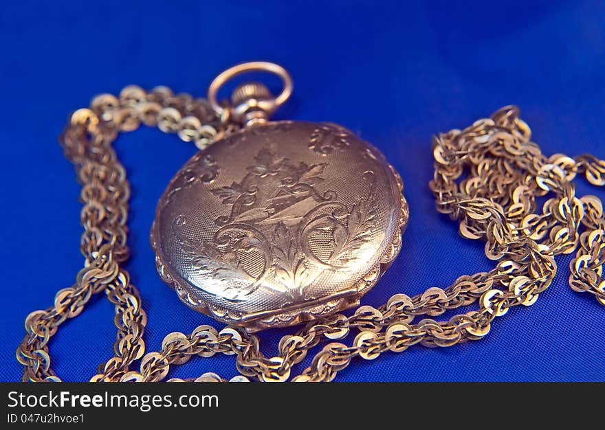 Antique pocket-watch with chain on blue