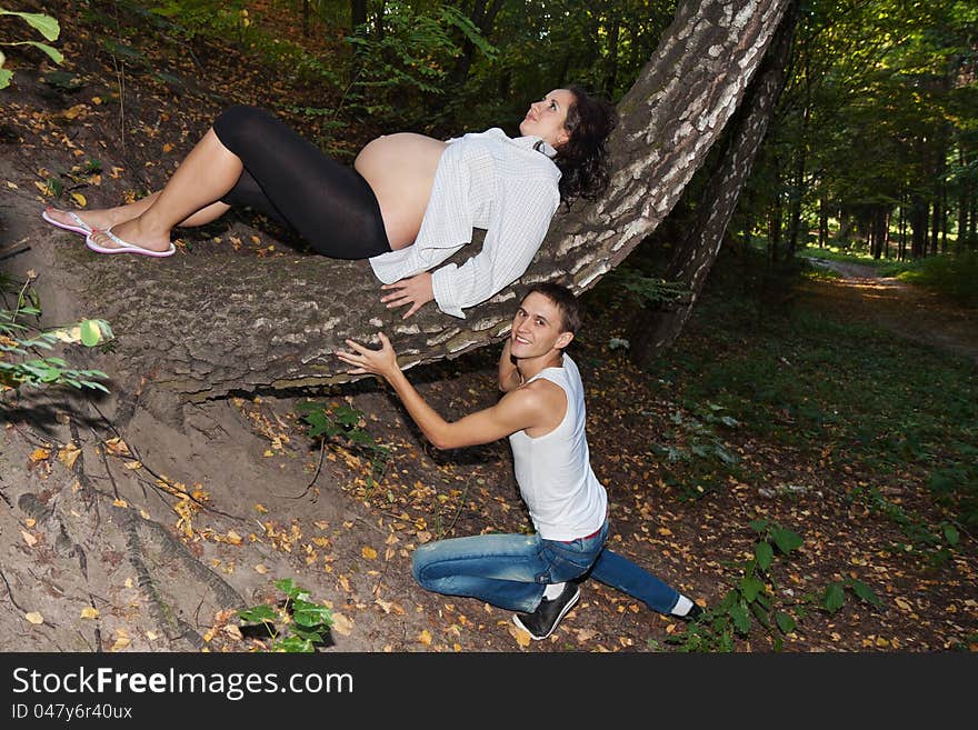 Pregnant couple resting in the forest