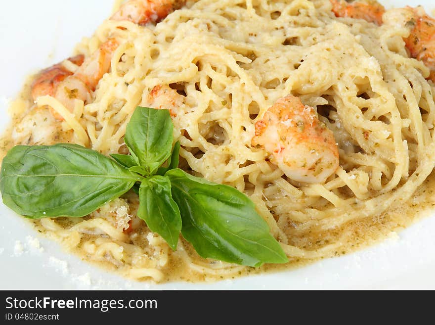 Noodles tagliolini with pesto and shrimps on a white background. Noodles tagliolini with pesto and shrimps on a white background.