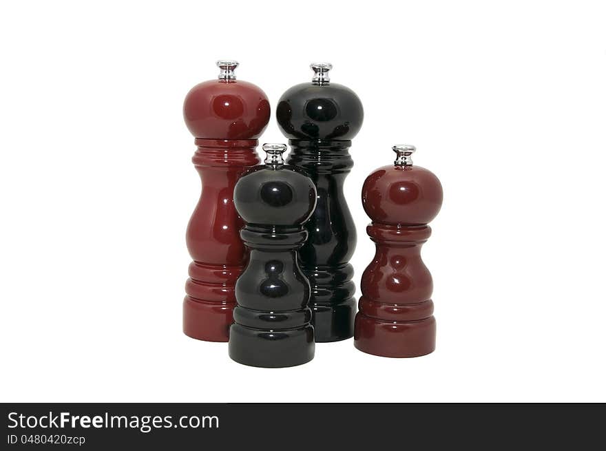 Four wooden pepper Mills on a white background