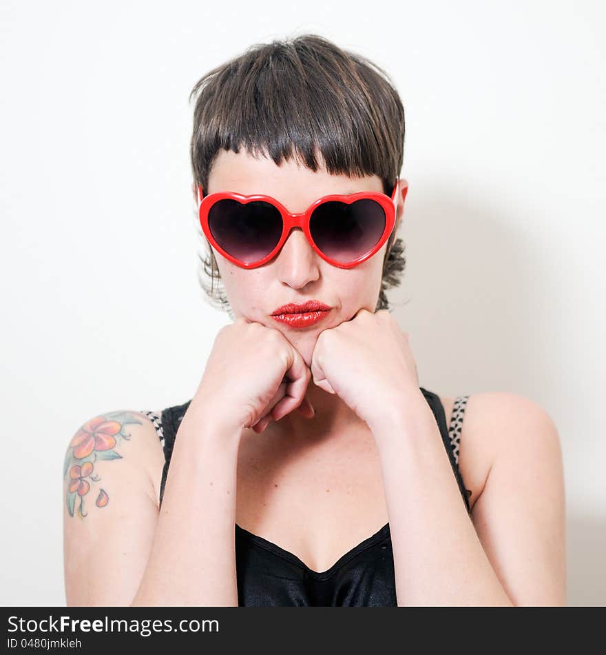 Portrait of a funny woman with red heart sunglasses