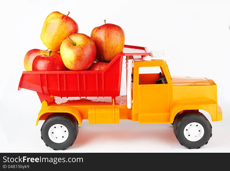 Toy lorry with apple on white