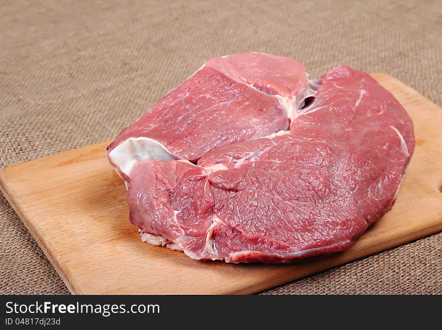 Piece of fresh beef on a wooden board