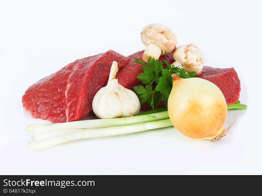 Raw meat and vegetables on white