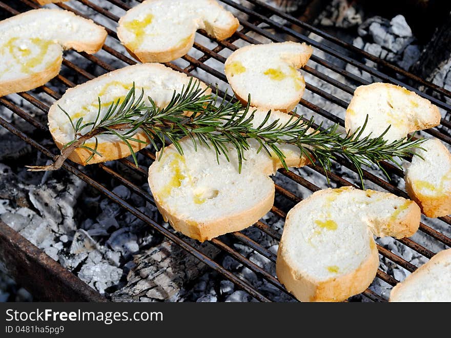 Slices of bread and rosemary on a barbecue